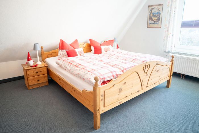 Schlafzimmer mit Doppelbett und Einzelbett unterm Dach