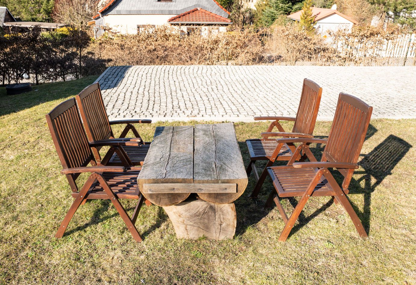 Sitzecke mit Holztisch neben dem gepflasterten Stellplatz